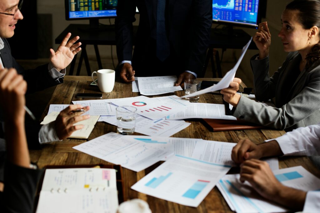 Professionals gathered around a table discussing financial documents.